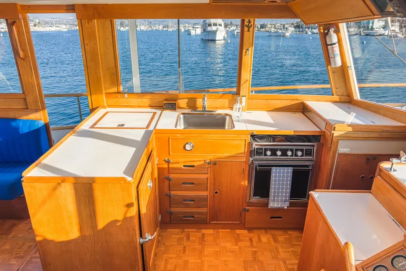 Slide: The Image of 1984 Grand Banks 42 Classic yacht interior with wooden cabinetry and ocean view. - 32