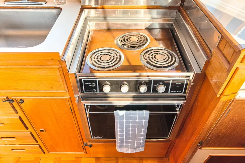 Slide: The Image of 1984 Grand Banks 42 Classic kitchen with stove, oven, and wooden cabinetry. - 35