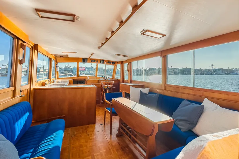 Slide: The Image of Interior of 1984 Grand Banks 42 Classic yacht with blue seating and large windows. - 36