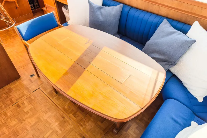 Slide: The Image of Interior of 1984 Grand Banks 42 Classic with wooden table and blue cushioned seating. - 39