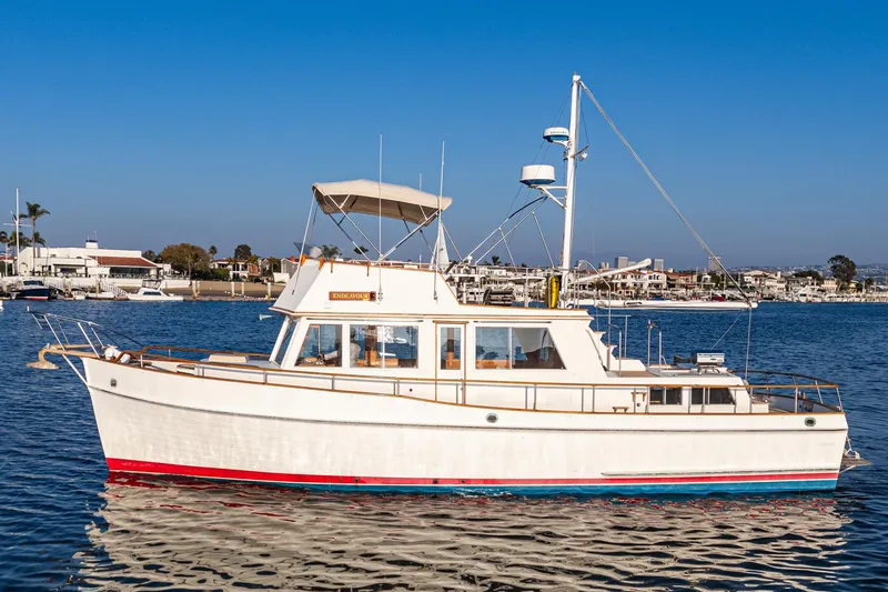 Slide: The Image of 1984 Grand Banks 42 Classic yacht on calm water, clear sky background. - 4