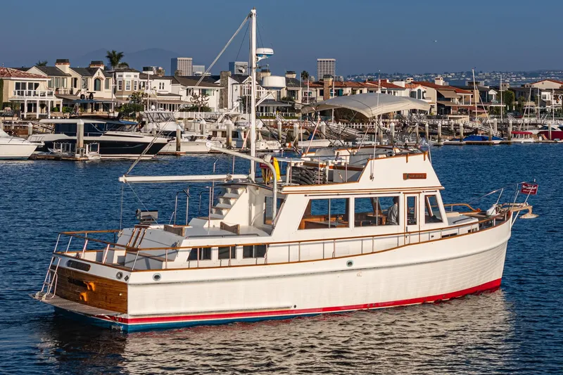 Slide: The Image of 1984 Grand Banks 42 Classic yacht cruising in a scenic harbor setting. - 6