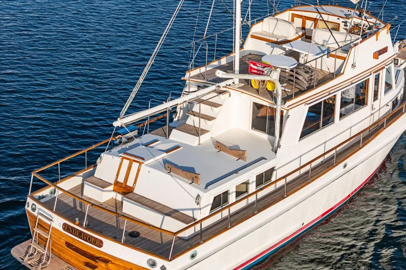 Slide: The Image of 1984 Grand Banks 42 Classic yacht on calm water, showcasing elegant design and spacious deck. - 7