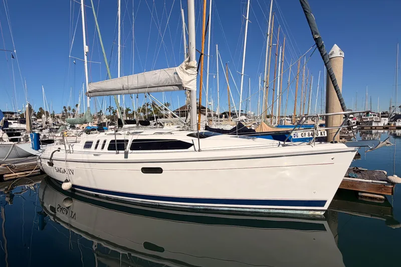 The Image of 1996 Hunter 336 sailboat docked in marina, clear blue sky background. - 0
