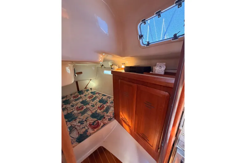 Slide: The Image of Interior cabin of 1996 Hunter 336 sailboat with wooden cabinets and floral bedding. - 35