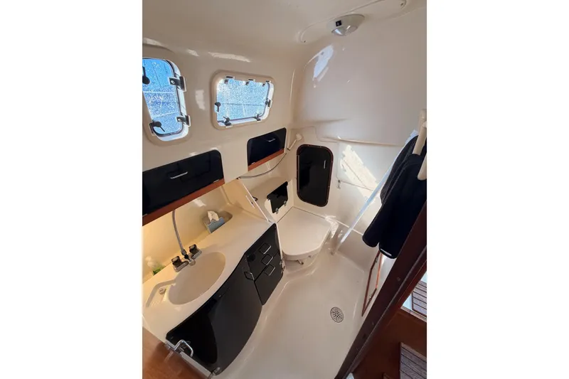 Slide: The Image of Interior of 1996 Hunter 336 sailboat bathroom with sink, toilet, and portholes. - 40