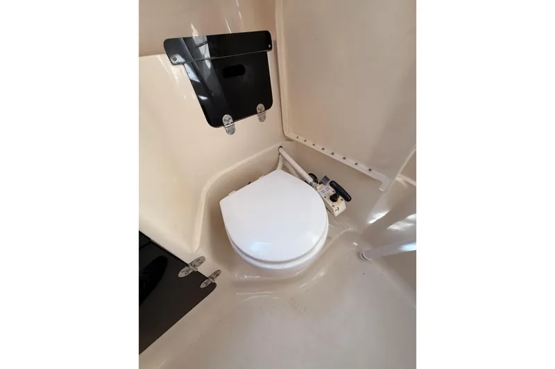 Slide: The Image of 1996 Hunter 336 boat bathroom with compact toilet and beige interior. - 41
