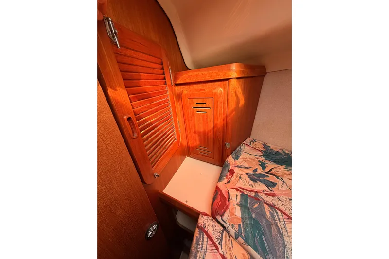 Slide: The Image of Interior of 1996 Hunter 336 sailboat with wooden cabinetry and colorful bedding. - 51