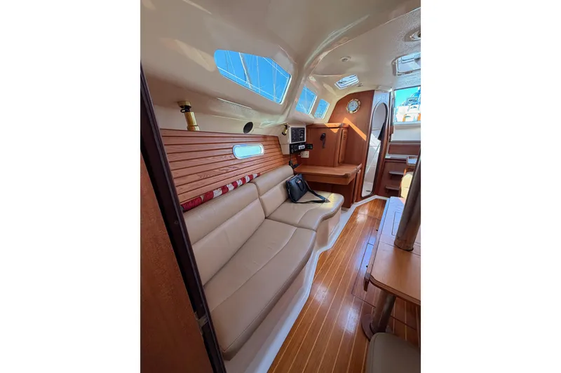 Slide: The Image of Interior of 1996 Hunter 336 sailboat with wooden flooring and beige seating. - 53
