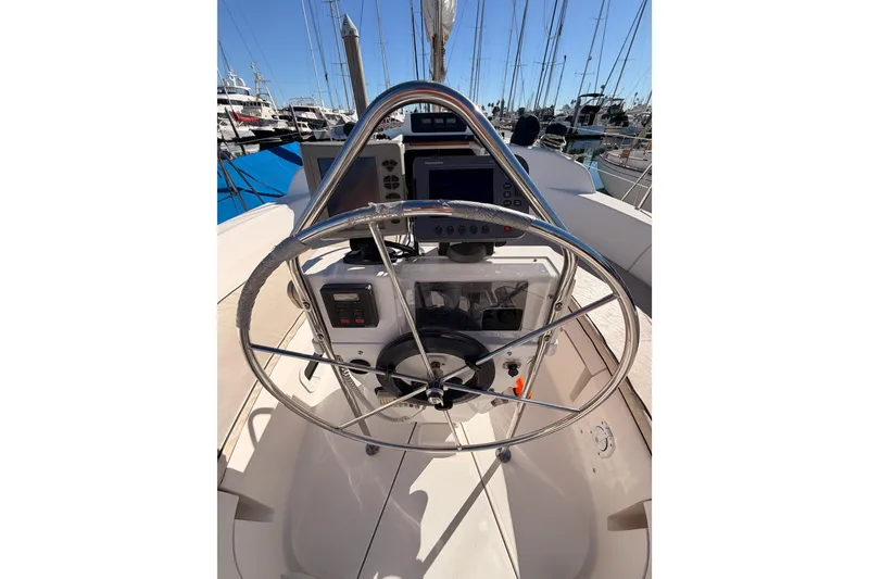Slide: The Image of Steering wheel and controls of a 1996 Hunter 336 sailboat in a marina. - 6