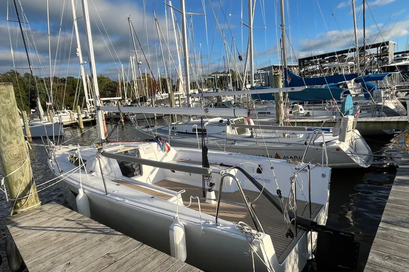 Slide: The Image of 2025 Zonda Yachts Z28 docked at marina, surrounded by sailboats under a partly cloudy sky. - 19