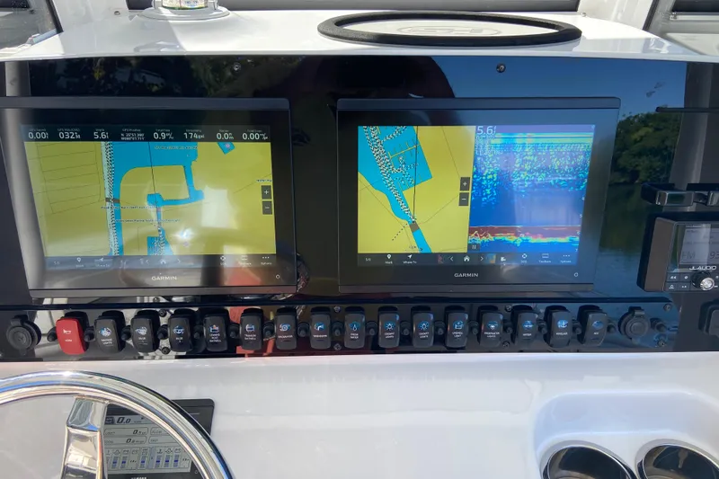 Slide: The Image of 2023 Sea Hunt Gamefish 27 dashboard with dual Garmin navigation displays. - 11