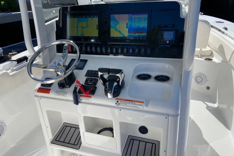 Slide: The Image of 2023 Sea Hunt Gamefish 27 console with dual displays and steering wheel. - 16