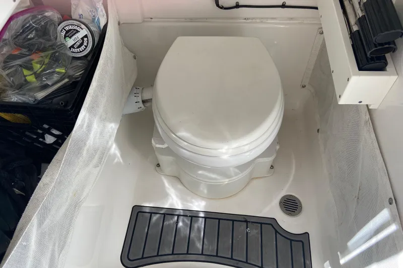 Slide: The Image of 2023 Sea Hunt Gamefish 27 boat toilet area with storage and accessories. - 27