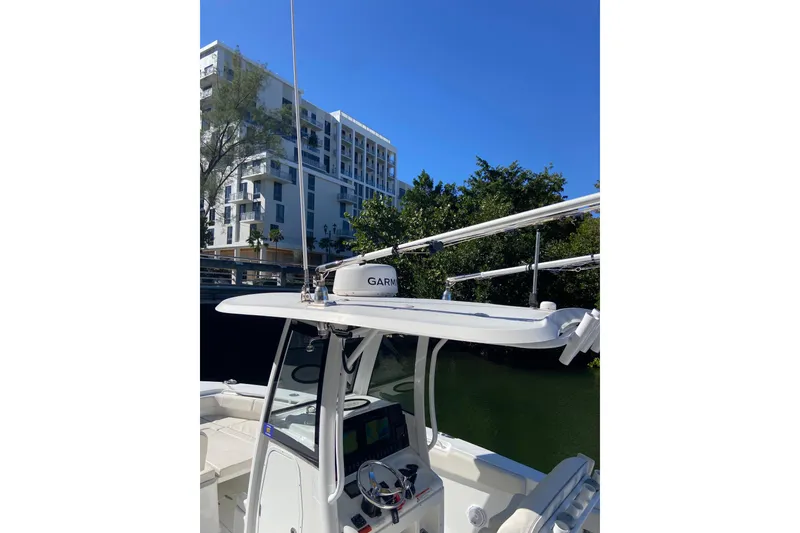 Slide: The Image of 2023 Sea Hunt Gamefish 27 boat with Garmin equipment, docked near modern buildings. - 29