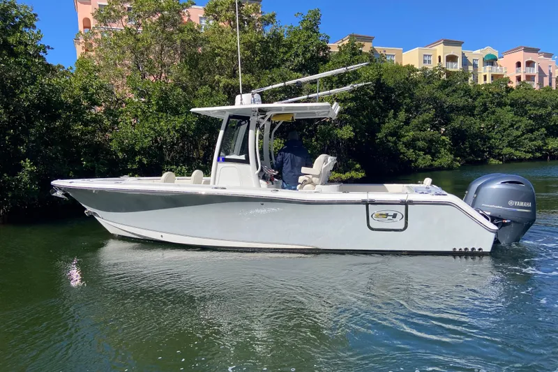 Slide: The Image of 2023 Sea Hunt Gamefish 27 boat with forward seating on a calm waterway. - 3