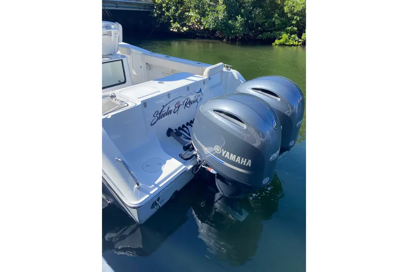 Slide: The Image of 2023 Sea Hunt Gamefish 27 with twin Yamaha engines, docked in calm waters. - 30
