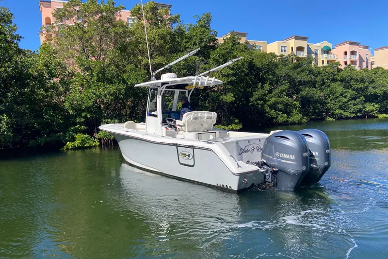 Slide: The Image of 2023 Sea Hunt Gamefish 27 boat with dual Yamaha engines on a scenic waterway. - 6