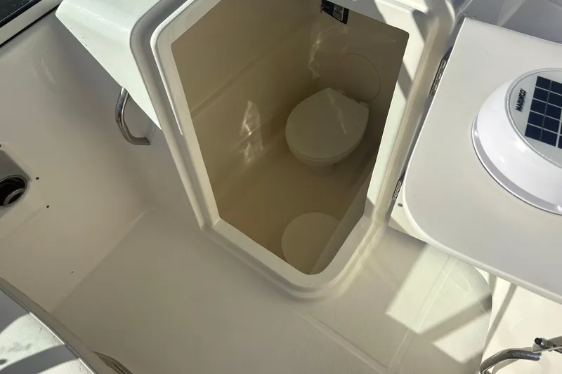 Slide: The Image of 2025 World Cat 230 DC boat interior with compact marine toilet. - 10