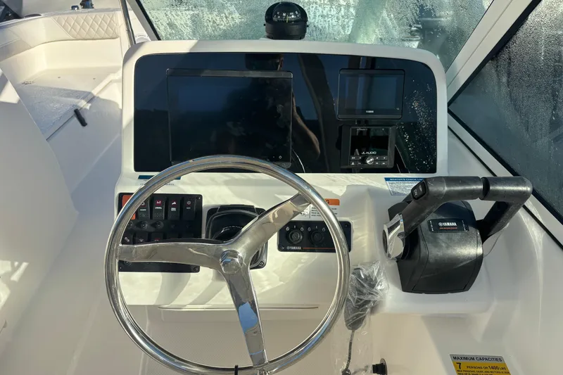 Slide: The Image of 2025 World Cat 230 DC boat dashboard with steering wheel and Yamaha controls. - 11