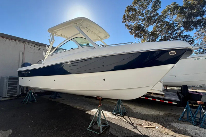 Slide: The Image of 2025 World Cat 230 DC boat on stands, outdoor display. - 2