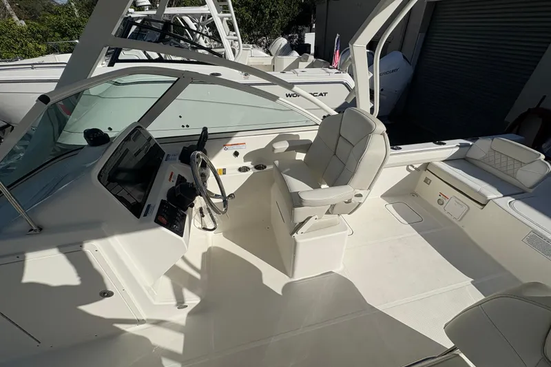 Slide: The Image of 2025 World Cat 230 DC boat interior with steering wheel and seating area. - 6