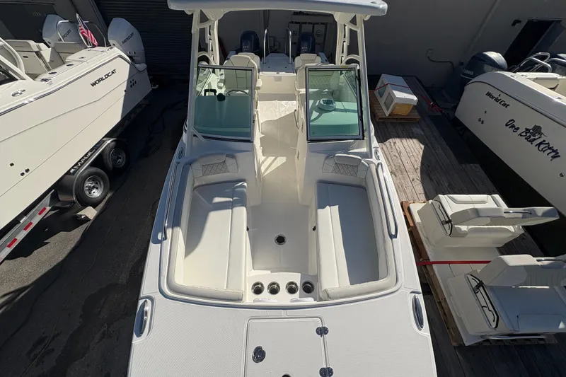 Slide: The Image of 2025 World Cat 230 DC boat with spacious seating and modern design in a marina setting. - 8