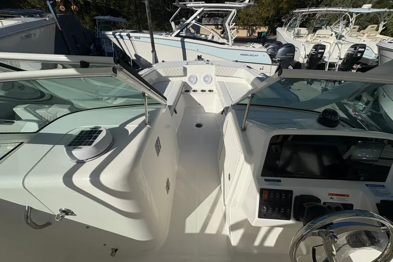 Slide: The Image of 2025 World Cat 230 DC boat interior with modern dashboard and seating area. - 9
