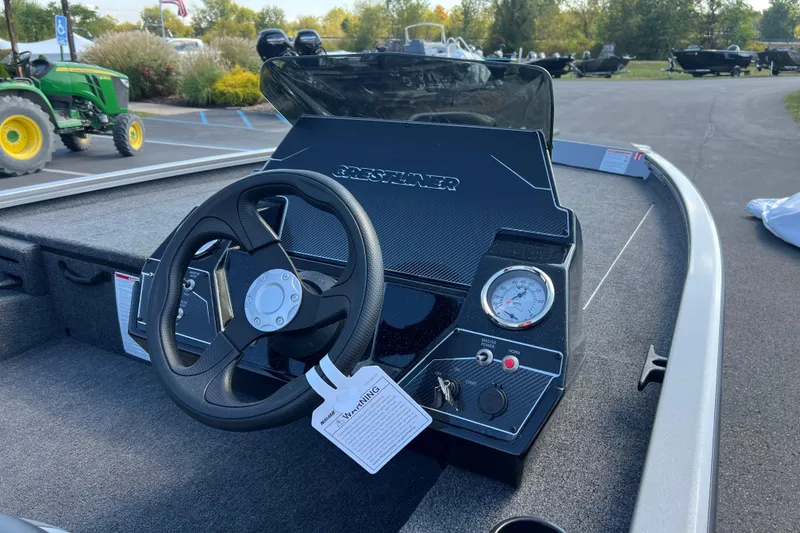 Slide: The Image of 2026 Crestliner XF 189 boat dashboard with steering wheel and gauges in a parking lot. - 8