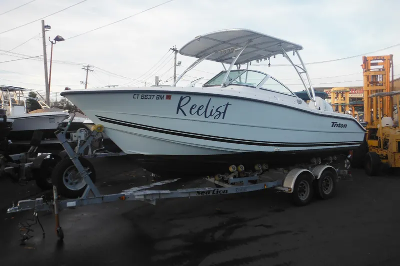 The Image of 2006 Triton 225 DC boat on trailer outdoors. - 1