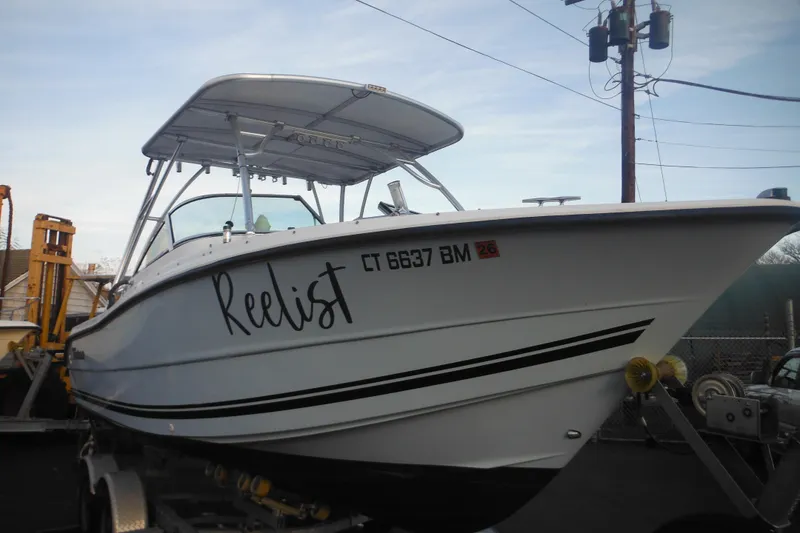 Slide: The Image of 2006 Triton 225 DC boat named "Reelist" on trailer, side view. - 10