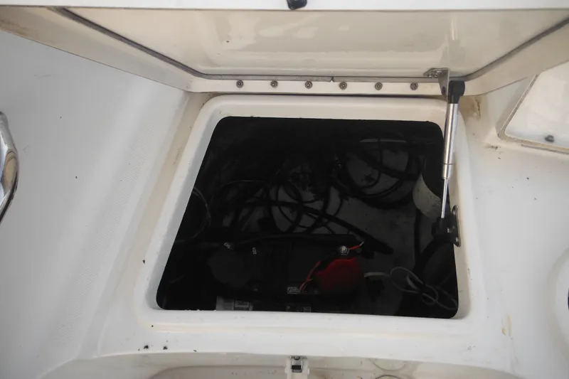 Slide: The Image of Open storage compartment on a 2006 Triton 225 DC boat, showing interior wiring. - 18
