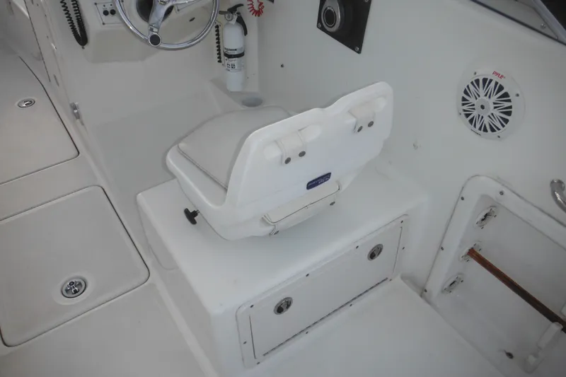 Slide: The Image of 2006 Triton 225 DC boat interior with white seating and steering wheel. - 22