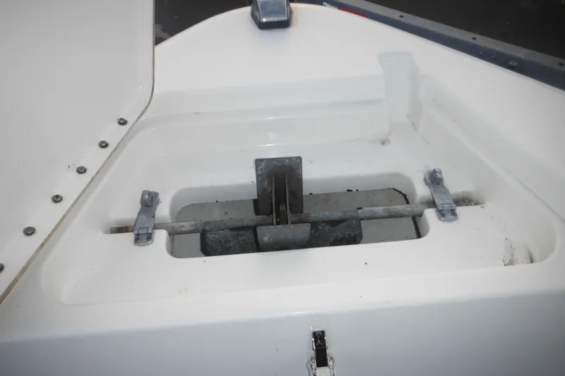 Slide: The Image of Anchor compartment of a 2006 Triton 225 DC boat, featuring metal hinges and latch. - 25