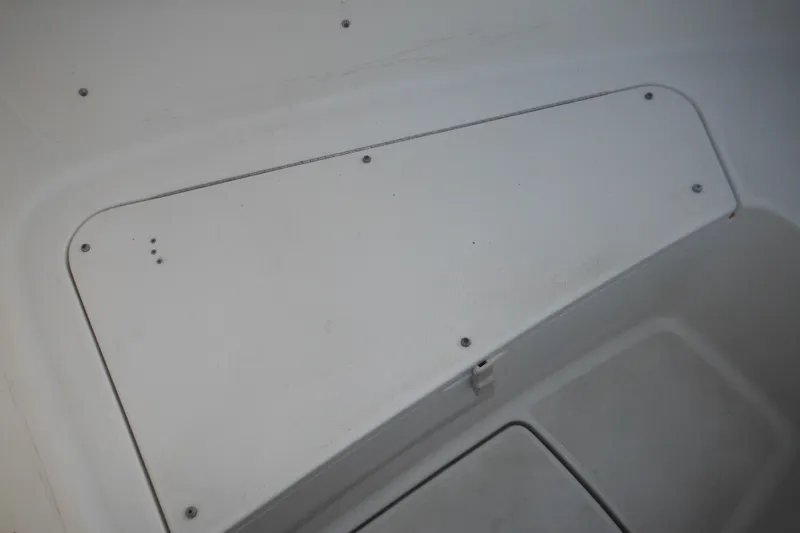 Slide: The Image of Storage compartment on a 2006 Triton 225 DC boat, featuring a white hatch cover. - 30