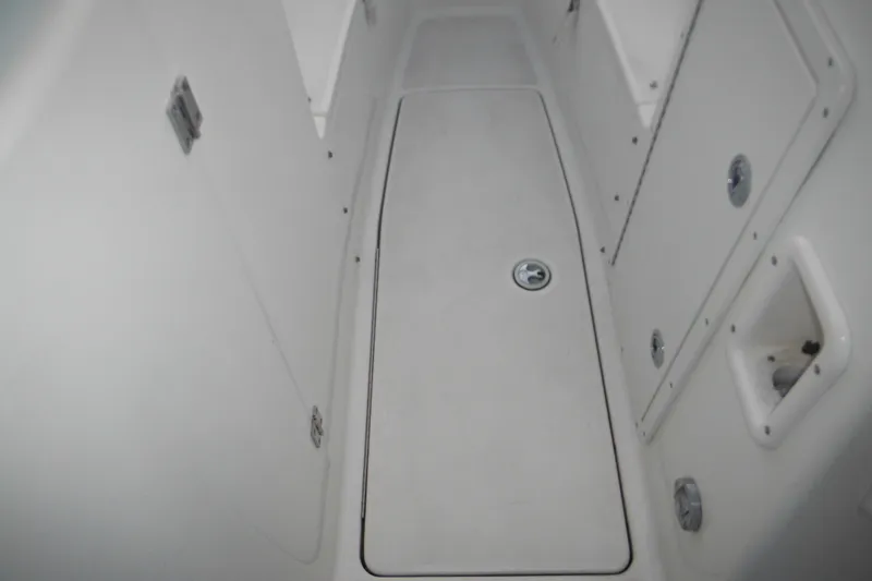 Slide: The Image of 2006 Triton 225 DC boat interior, featuring storage compartments and sleek white design. - 32