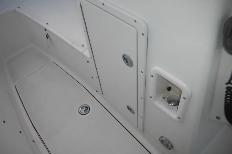 Slide: The Image of 2006 Triton 225 DC boat interior, featuring storage compartments and clean white surfaces. - 35