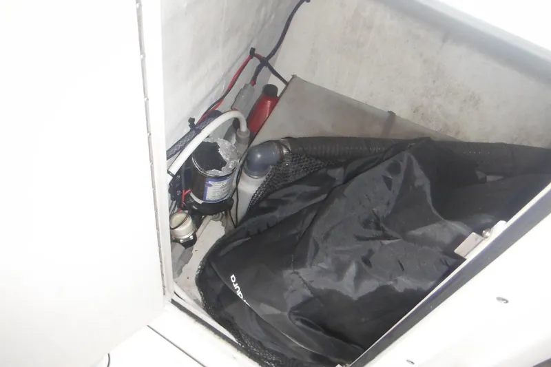 Slide: The Image of Storage compartment of a 2006 Triton 225 DC boat with equipment and supplies. - 36