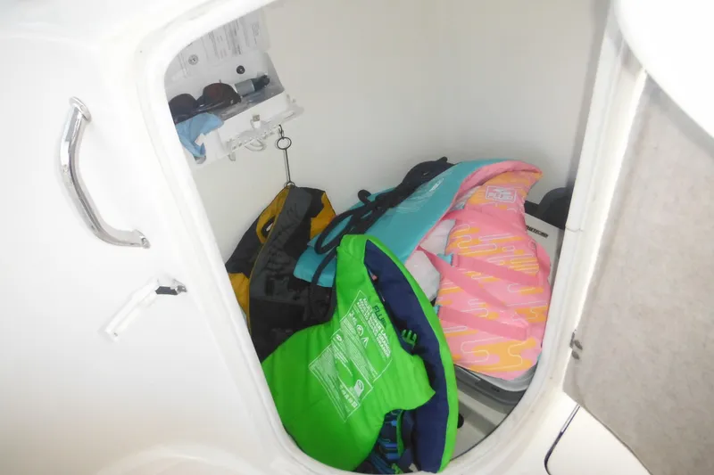 Slide: The Image of Storage compartment in a 2006 Triton 225 DC boat with life jackets and accessories. - 38