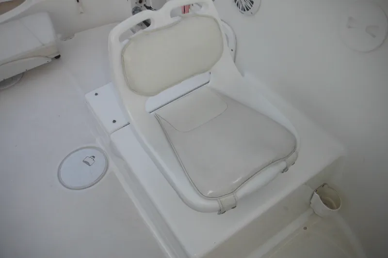 Slide: The Image of White seat on 2006 Triton 225 DC boat interior, featuring clean design and cup holder. - 40