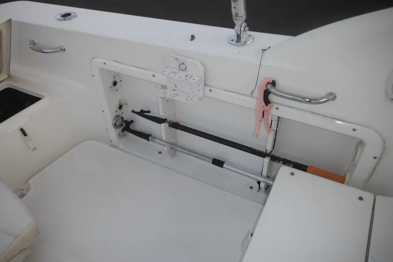 Slide: The Image of 2006 Triton 225 DC boat interior with fishing rod storage and seating area. - 43