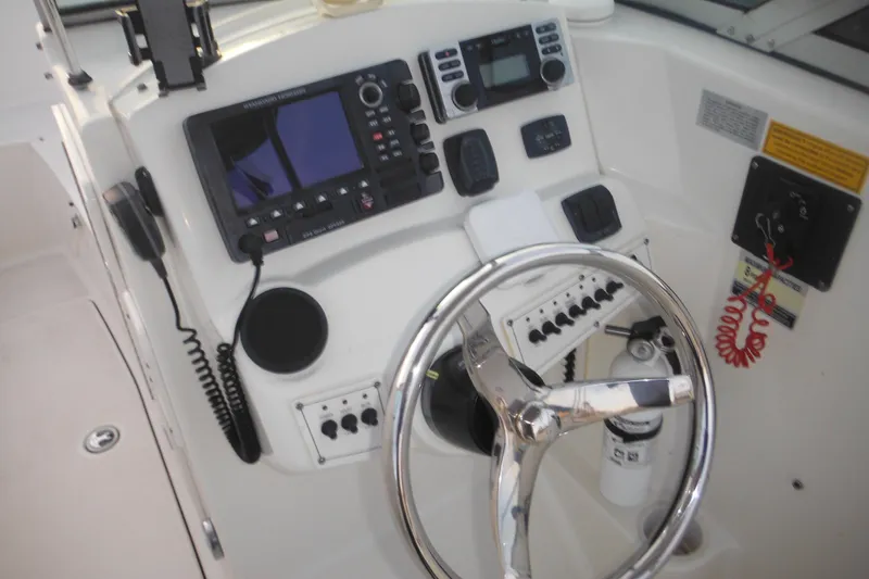 Slide: The Image of 2006 Triton 225 DC boat dashboard with steering wheel and navigation controls. - 46