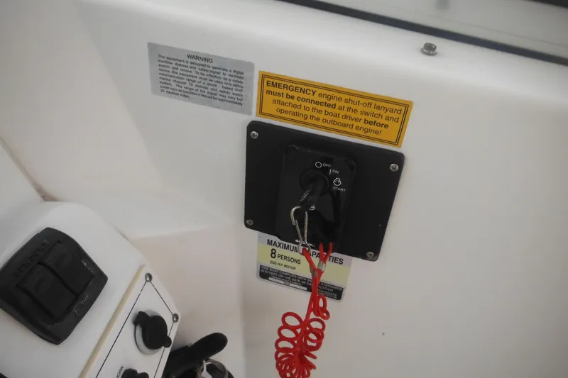 Slide: The Image of Control panel of a 2006 Triton 225 DC boat with emergency engine shut-off lanyard. - 49