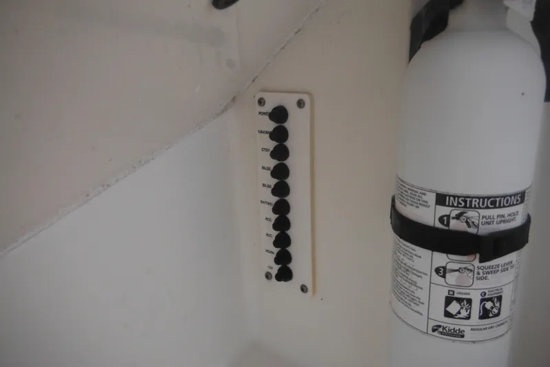 Slide: The Image of Control panel and fire extinguisher on 2006 Triton 225 DC boat. - 50