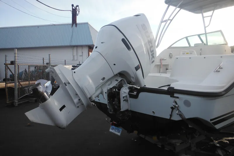 Slide: The Image of 2006 Triton 225 DC boat with Suzuki outboard motor in a marina setting. - 7