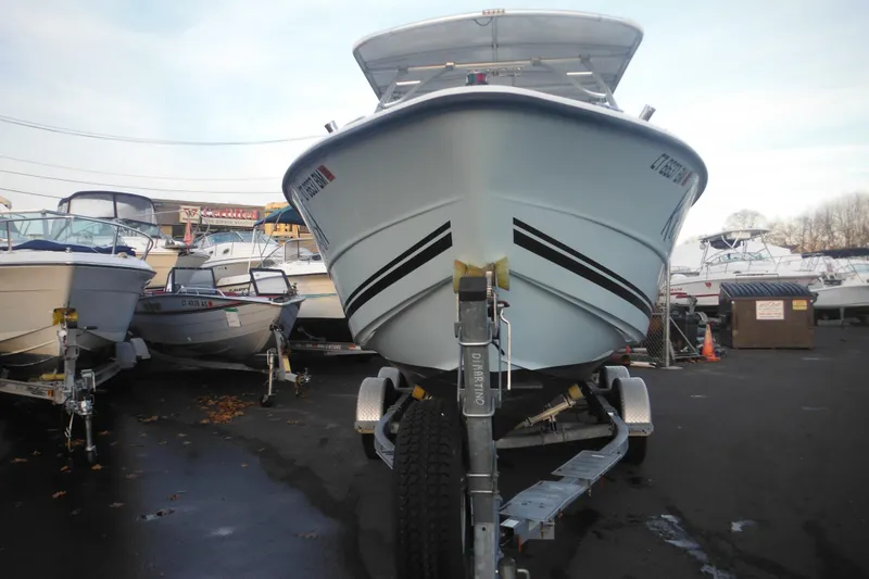 Slide: The Image of 2006 Triton 225 DC boat on trailer in a marina parking lot. - 9