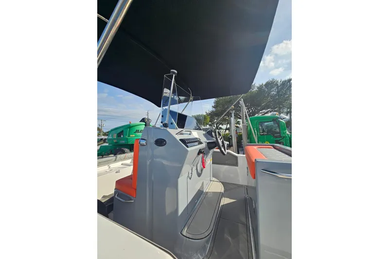 Slide: The Image of 2026 Murano Yachts Rovercat 205 interior with modern helm and seating under canopy. - 10