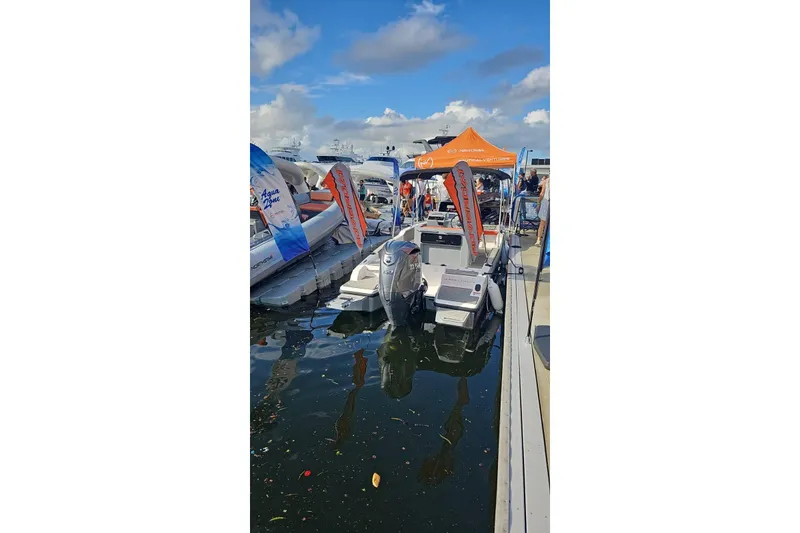 Slide: The Image of 2026 Murano Yachts Rovercat 205 docked at marina with promotional banners. - 13