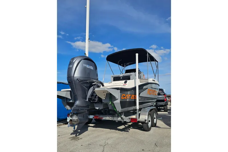 Slide: The Image of 2026 Murano Yachts Rovercat 205 on trailer, featuring Yamaha outboard motor, under clear blue sky. - 2