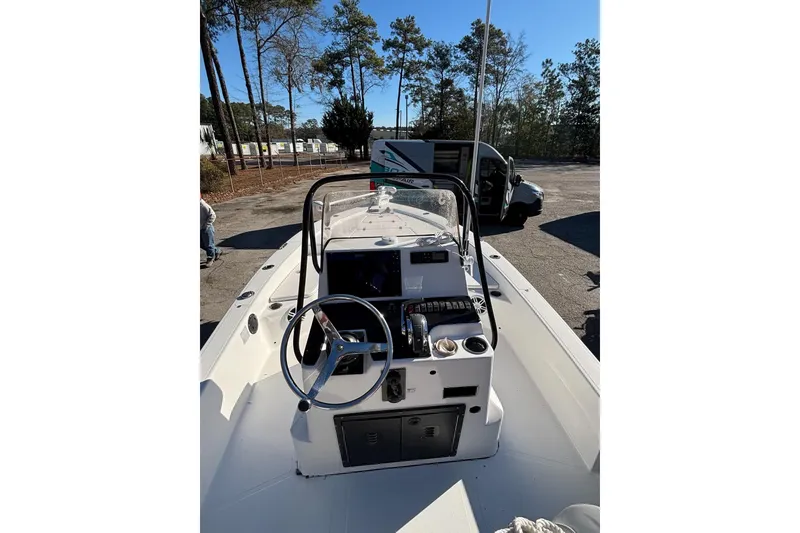 Slide: The Image of 2018 BlackJack 224 boat cockpit with steering wheel and control panel, parked outdoors. - 14